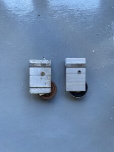 Sliding door roller assembly components — wheel, housing, and adjustment screw